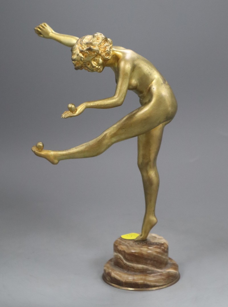 An Art Deco style bronze figure of a nude female juggler, signed to the base, C J R Colinet, overall 25cm